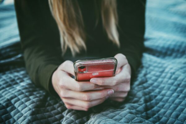woman holding red and silver can dating app